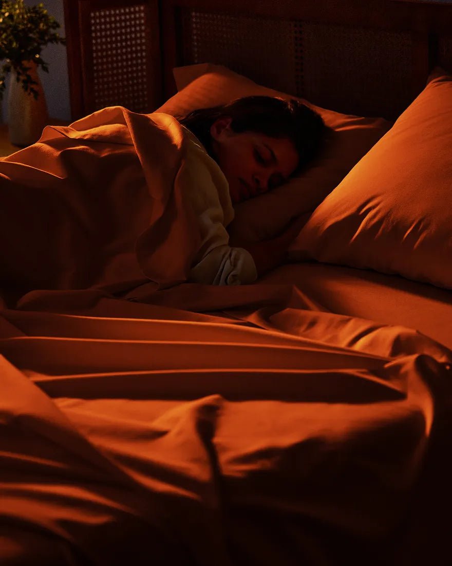 Person asleep on RUIE brushed cotton pillowcases and sheets in terracotta
